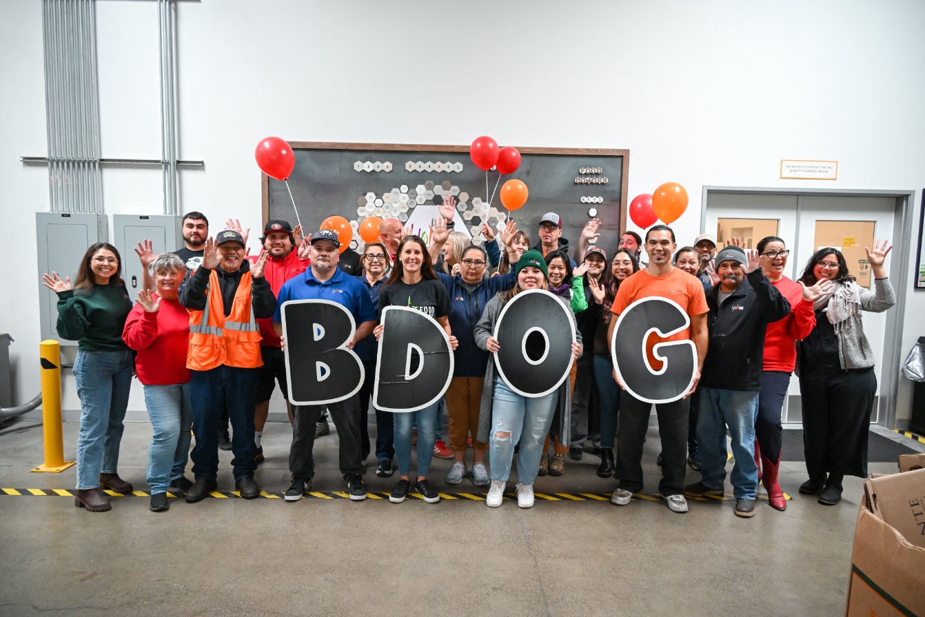 Nonprofit leaders of the Yolo Food Bank holding up big letters that spell "BDOG"
